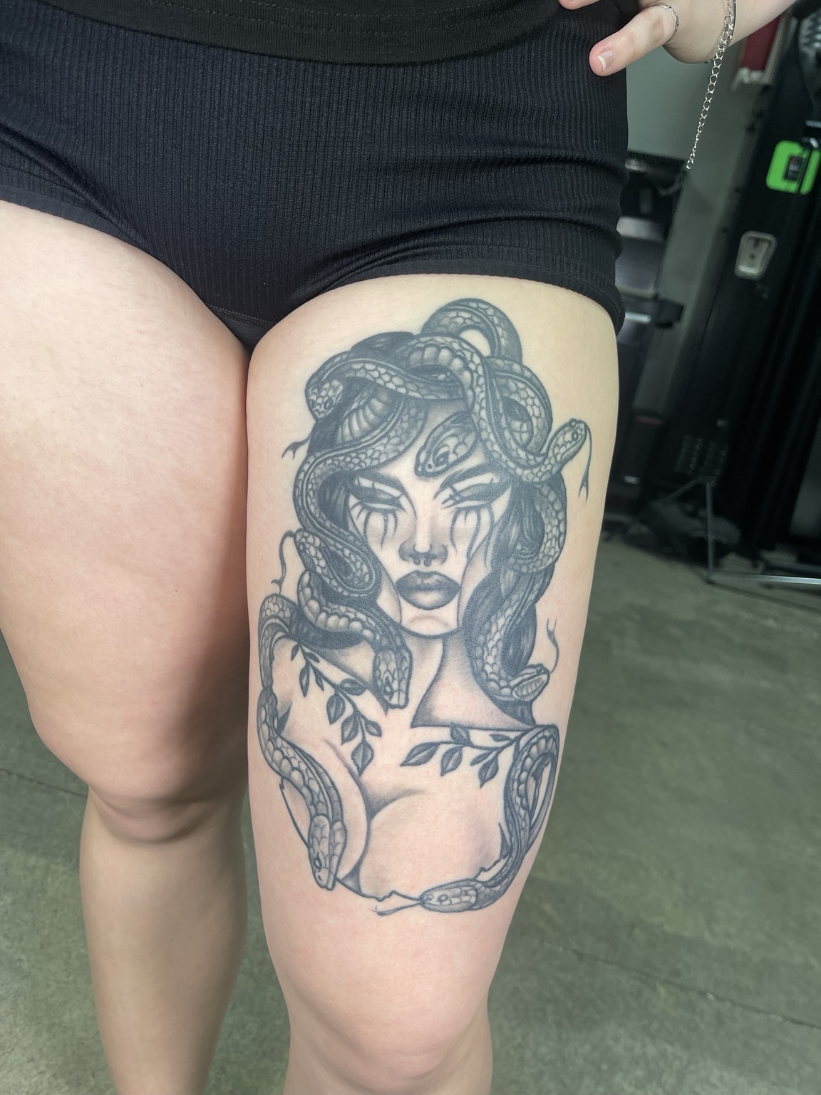 Illustrative woman and snake thigh tattoo