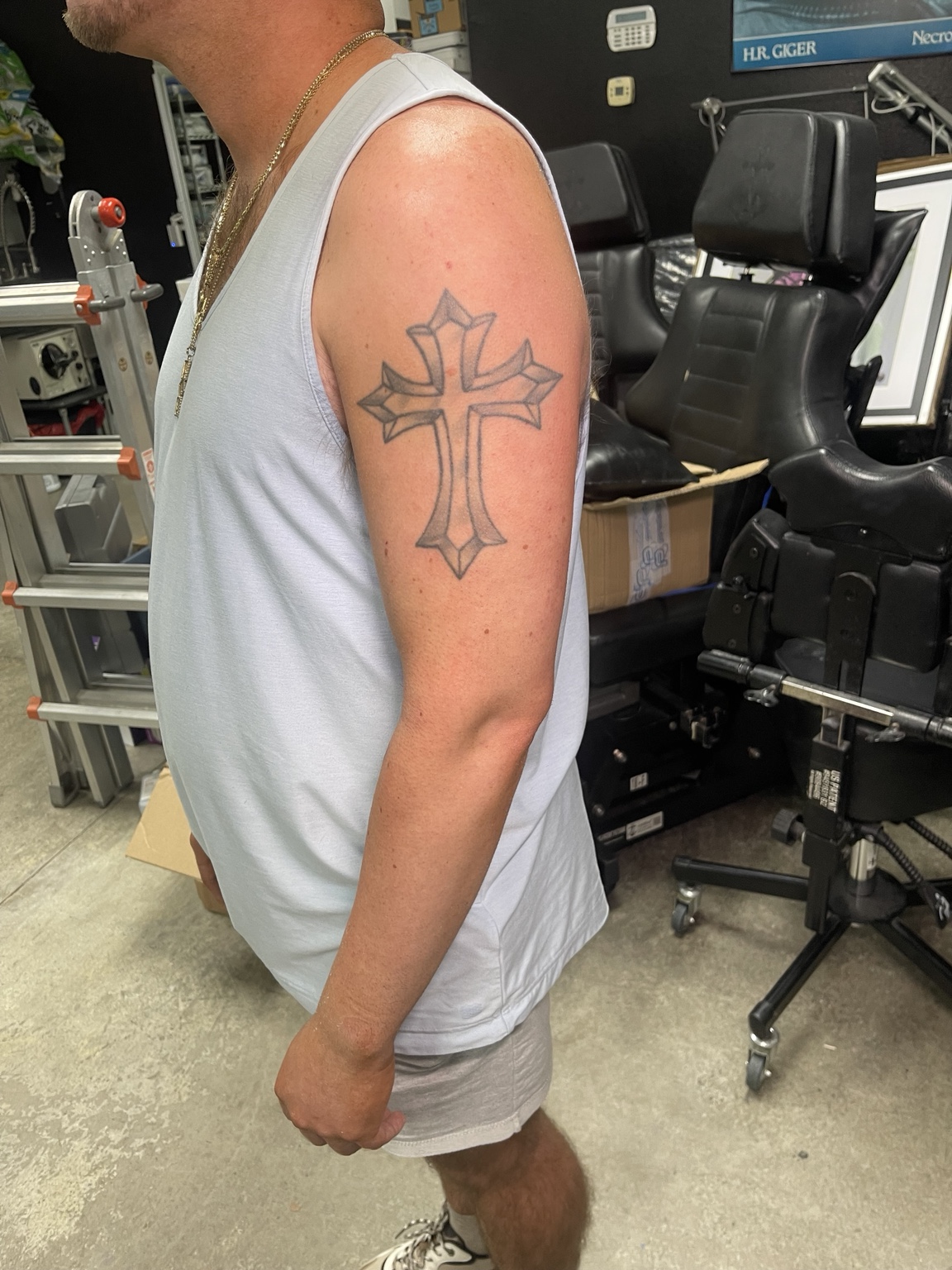 Cross upper arm tattoo