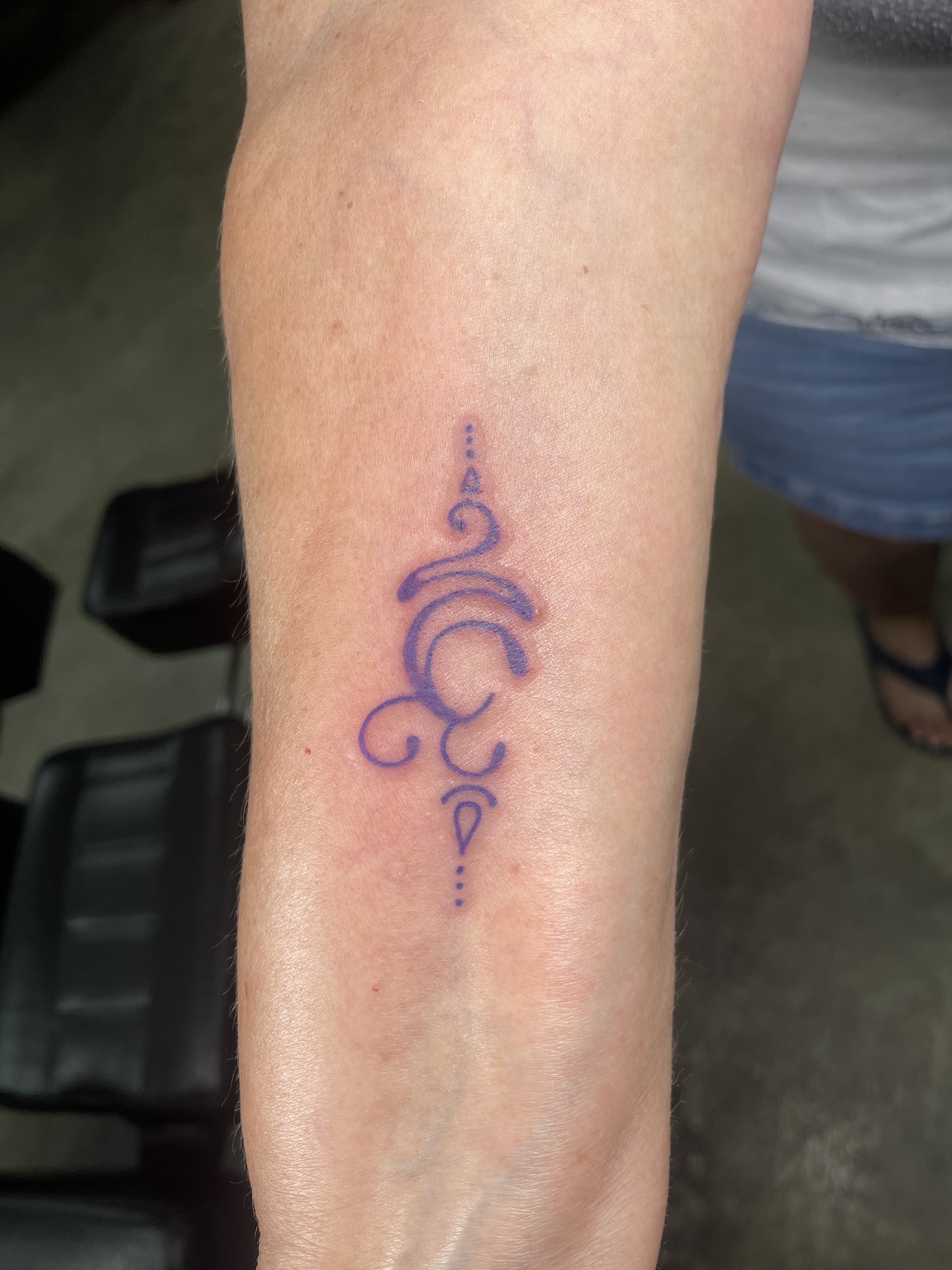Purple symbolic forearm tattoo