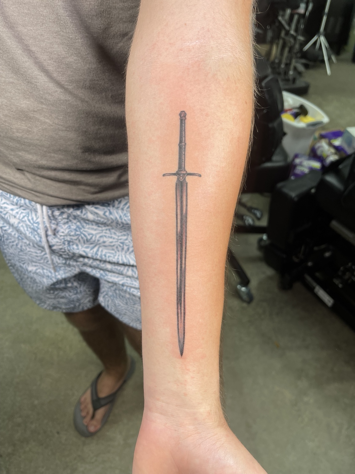 Fine black sword forearm tattoo