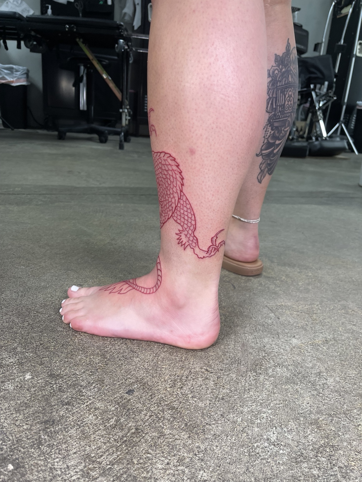 Red outline leg tattoo process detail