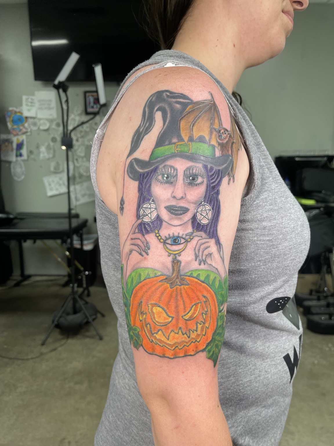 Witch and pumpkin upper arm tattoo