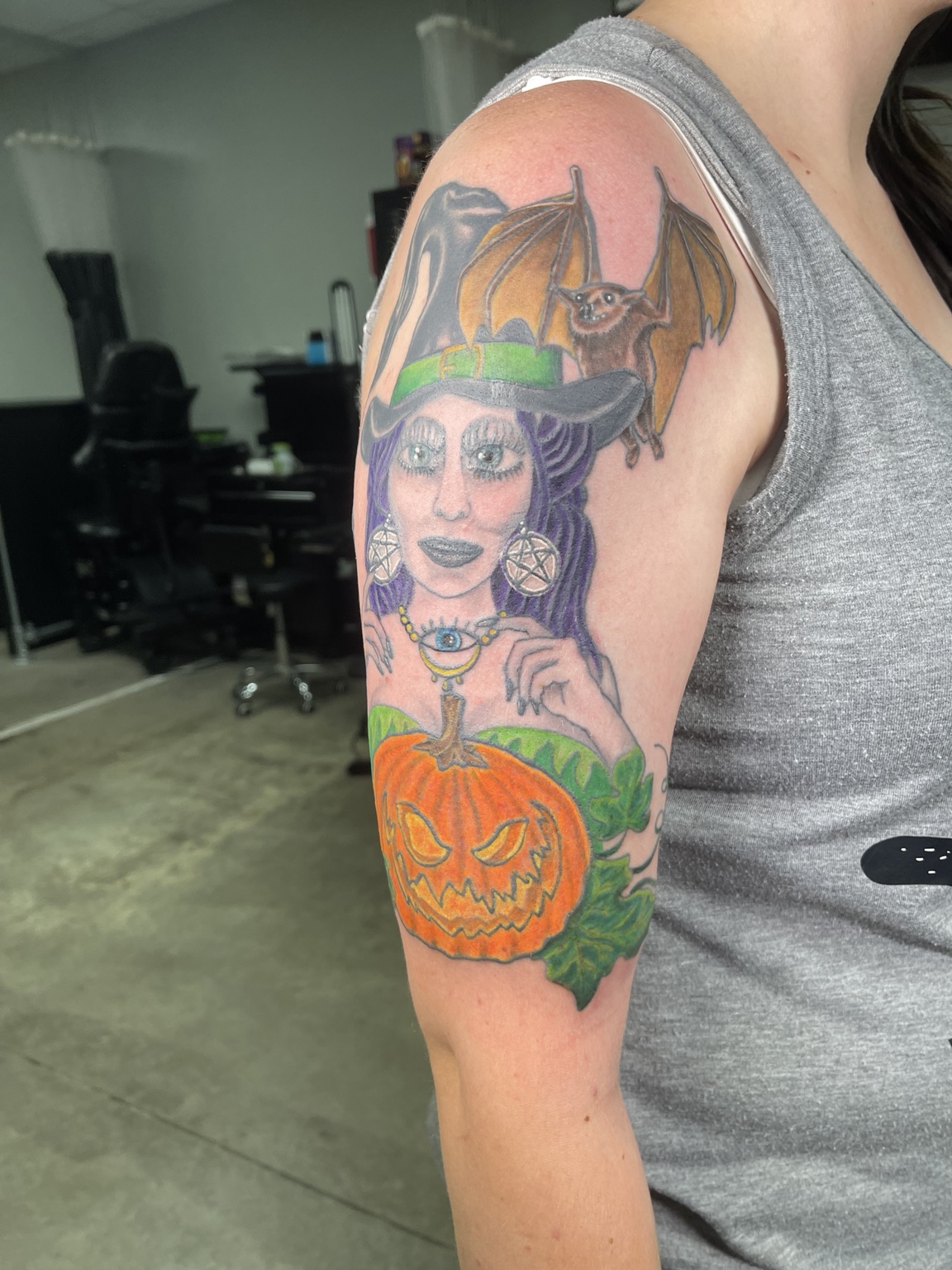 Witch and pumpkin upper arm tattoo